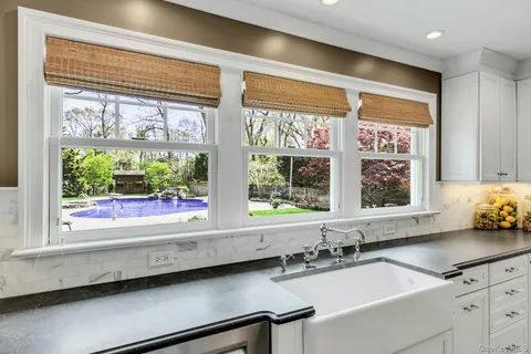 a bathroom with a sink and a large mirror next to a window