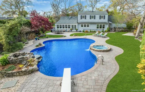 a view of a house with a yard patio and fire pit