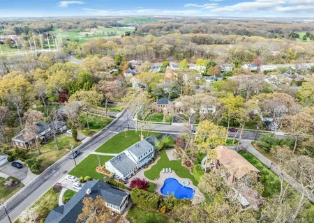 an aerial view of residential houses with outdoor space and street view