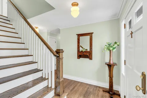 a view of a hallway with wooden floor and stairs