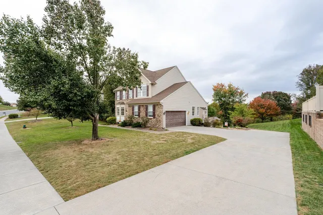 a front view of a house with a yard and trees
