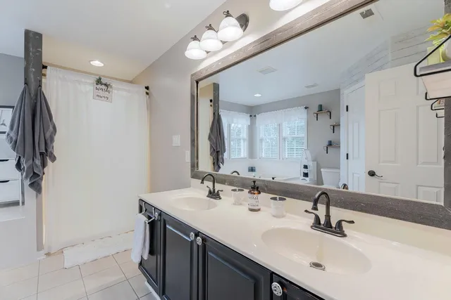 a bathroom with a sink a toilet and shower curtain