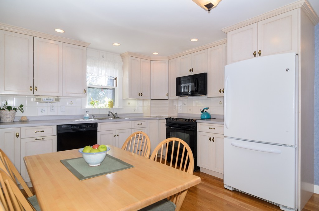 22 MacArthur Road Wellesley, MA 02482 - Photo 7 of 15 a kitchen with a refrigerator a stove top oven a sink dishwasher and white cabinets with wooden floor