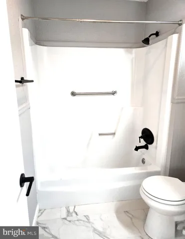 a bathroom with a toilet and a shower