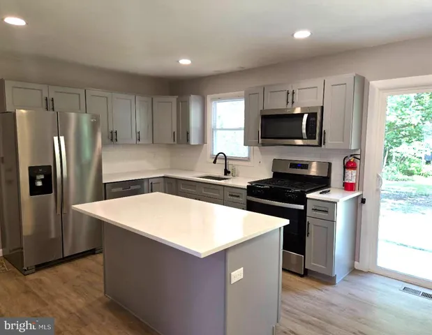 a kitchen with stainless steel appliances a stove microwave and a refrigerator