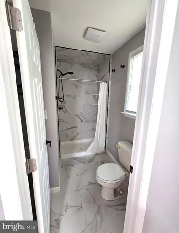 a bathroom with a toilet and a shower