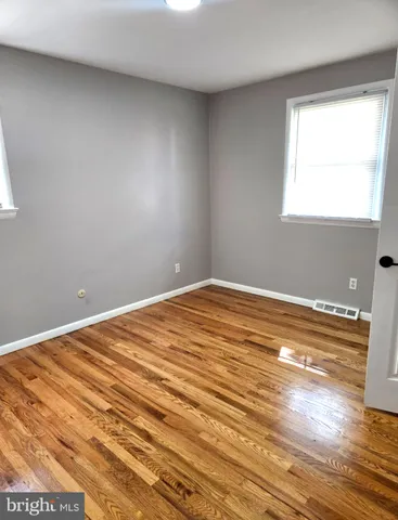 a view of a room with wooden floor and white walls