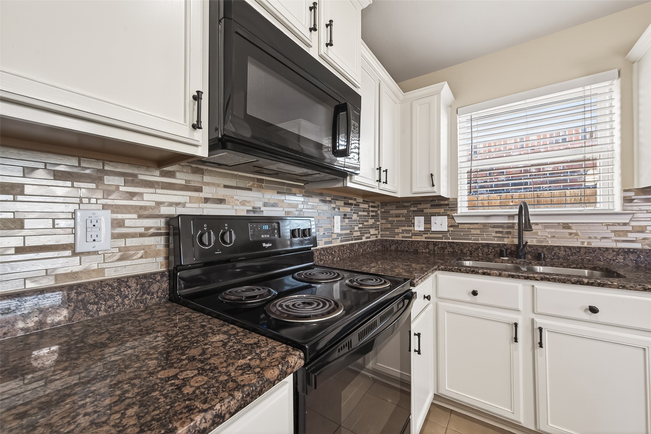 2319 Seabourne Trails Road Rosenberg, TX 77469 - Photo 14 of 36 a kitchen with granite countertop a stove sink and microwave
