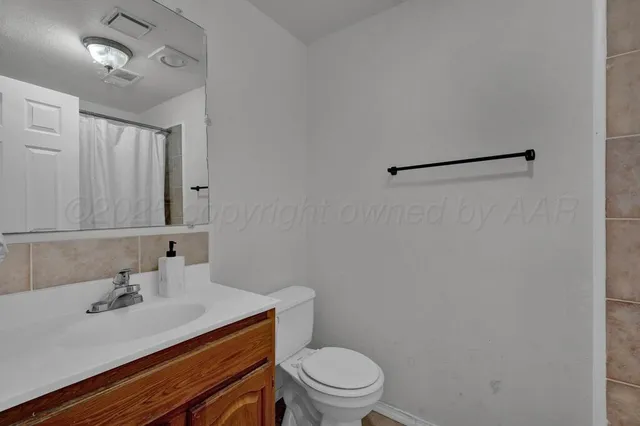 a bathroom with a sink mirror vanity and toilet