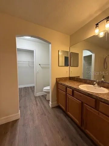 a spacious bathroom with a granite countertop sink and a mirror