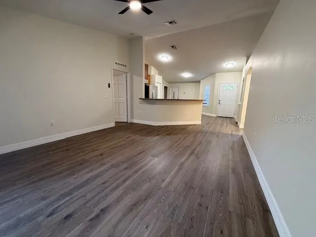 a view of a kitchen with wooden floor and a window