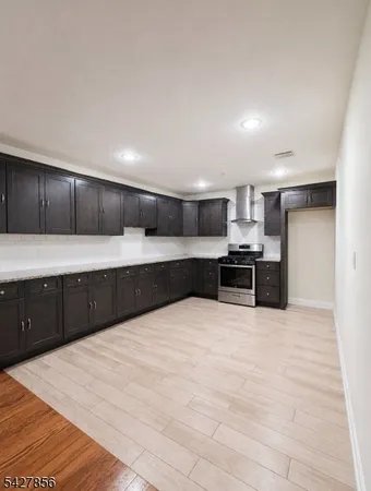 a large kitchen with a large counter top stainless steel appliances and cabinets