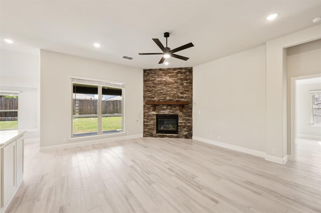 2018 Dundalk Lane Forney, TX 75126 - Photo 17 of 40 an empty room with wooden floor a ceiling fan and windows