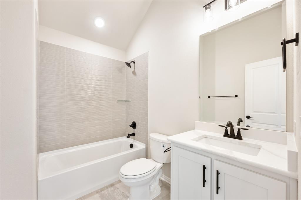 2018 Dundalk Lane Forney, TX 75126 - Photo 36 of 40 a bathroom with a sink a toilet a mirror a bathtub and shower