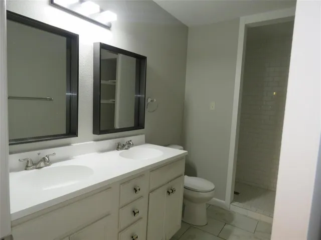 a bathroom with double sink and a mirror