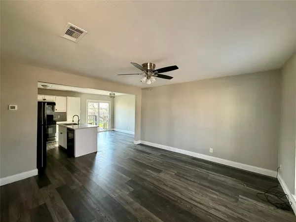 a view of an empty room with window and wooden floor