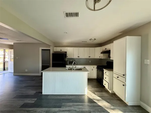a kitchen with a sink appliances and cabinets
