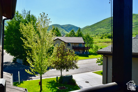 514 North Olympic Way Midway, UT 84049 - Photo 29 of 30 Property exterior featuring paved driveway, green lawn, mature trees, and a mountain backdrop