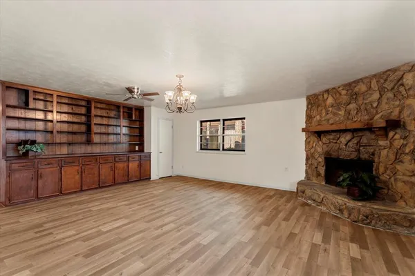 a view of an empty room with a fireplace and a window