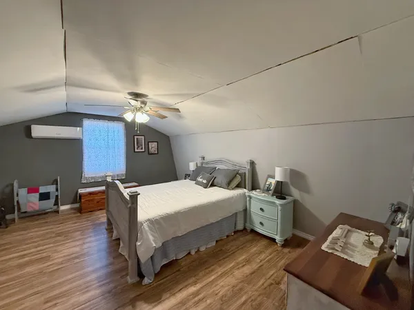 a spacious bedroom with a bed a couch and chandelier