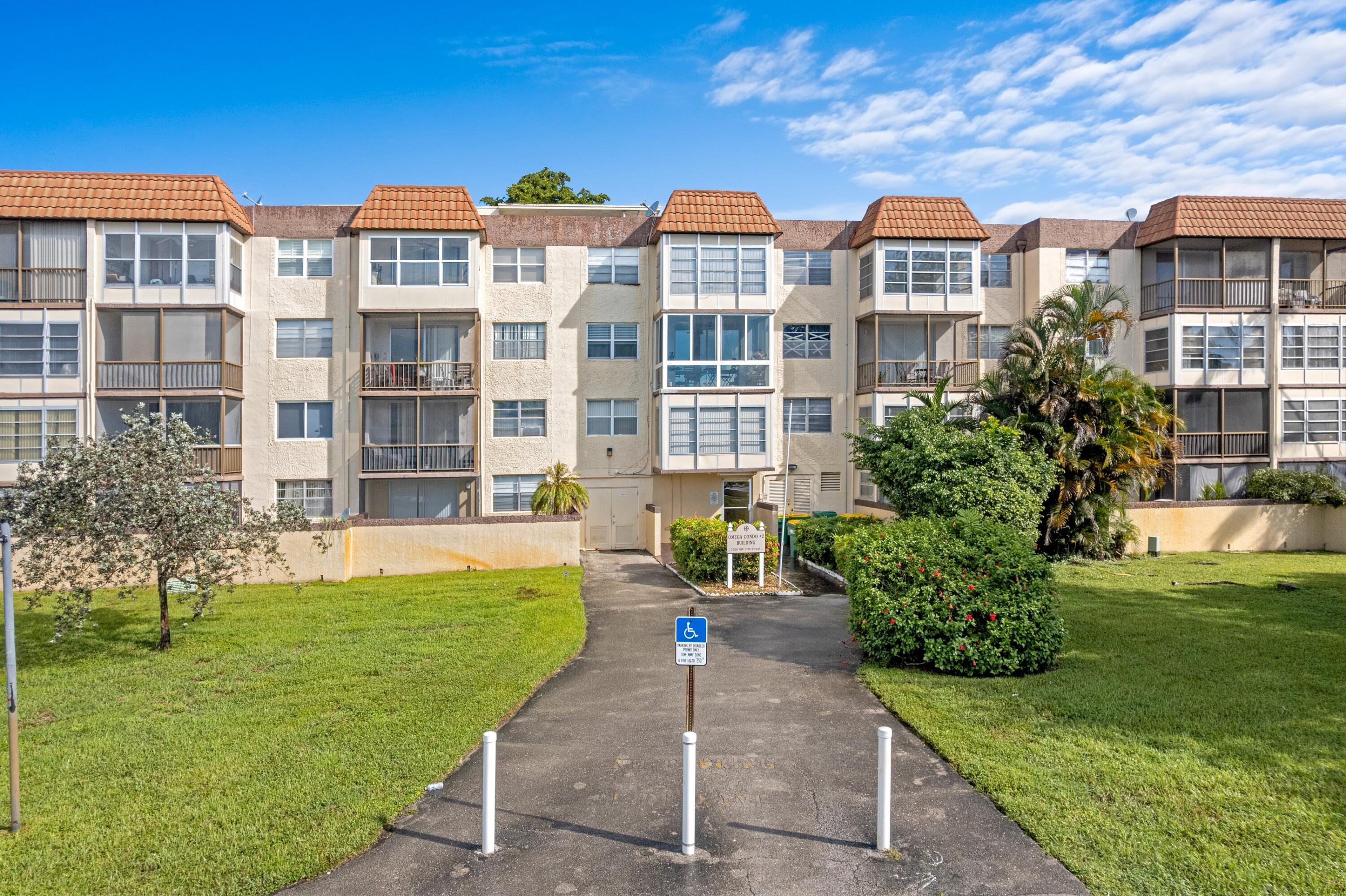 7000 Northwest 17th Street, Unit 419 Plantation, FL 33313 - Photo 17 of 23 a front view of a residential apartment building with a yard