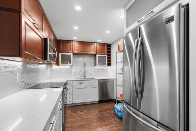 a kitchen with stainless steel appliances granite countertop a refrigerator a sink and a stove