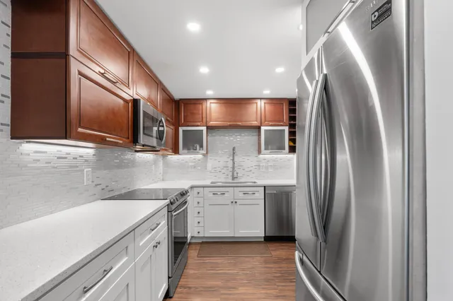 a kitchen with stainless steel appliances a refrigerator sink and microwave