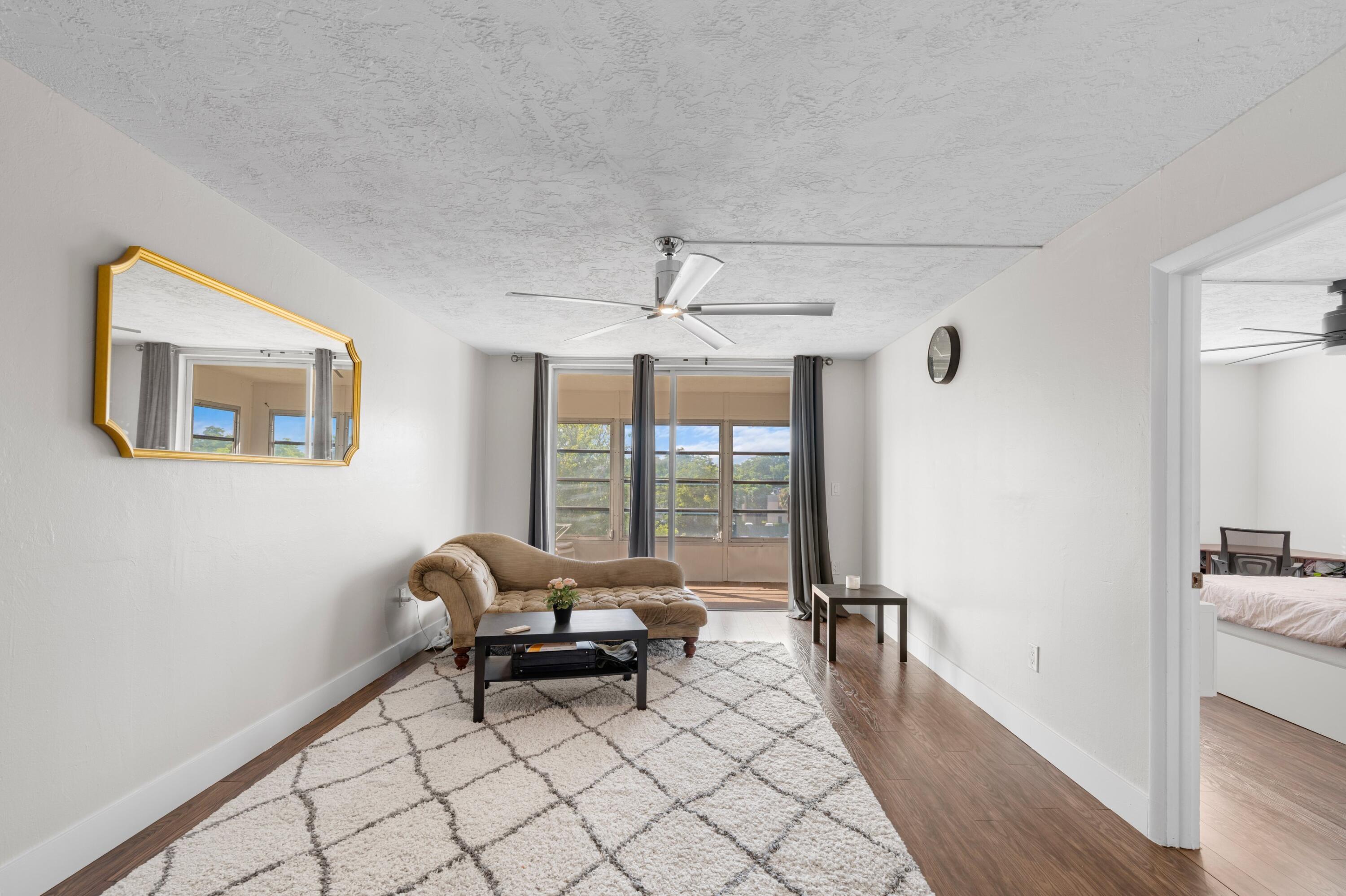 7000 Northwest 17th Street, Unit 419 Plantation, FL 33313 - Photo 9 of 23 a living room with furniture and a floor to ceiling window