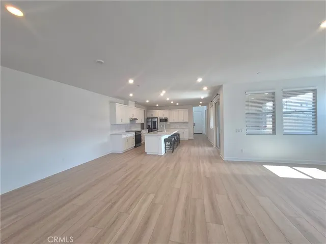 a view of a kitchen with wooden floor and a window