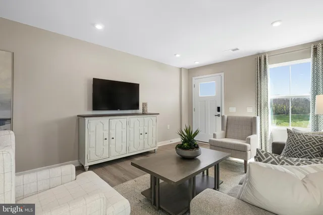 a living room with furniture a flat screen tv and a dining table