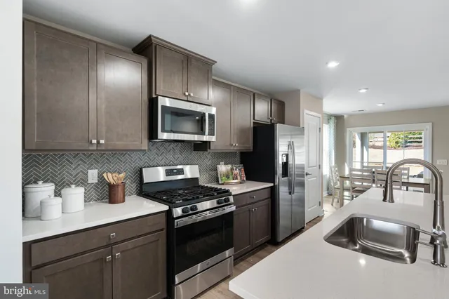 a kitchen with granite countertop a sink stainless steel appliances and cabinets