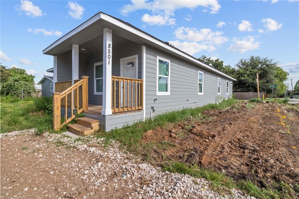 a view of backyard of house with wooden fence