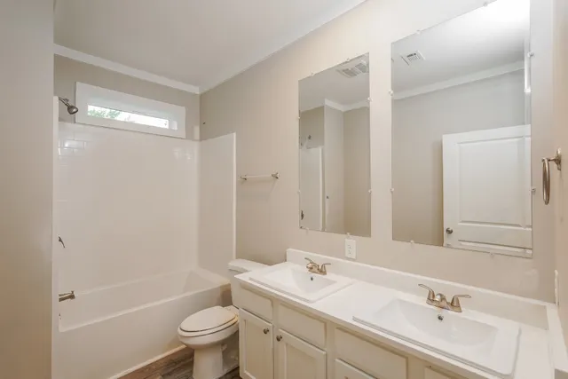 a bathroom with a granite countertop sink a toilet and a large mirror