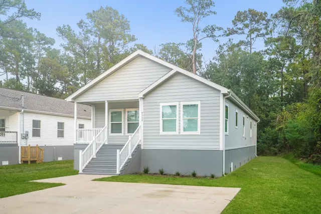 a front view of a house with a garden and yard
