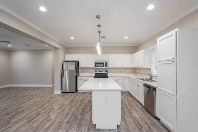 a kitchen with kitchen island a sink stainless steel appliances and cabinets
