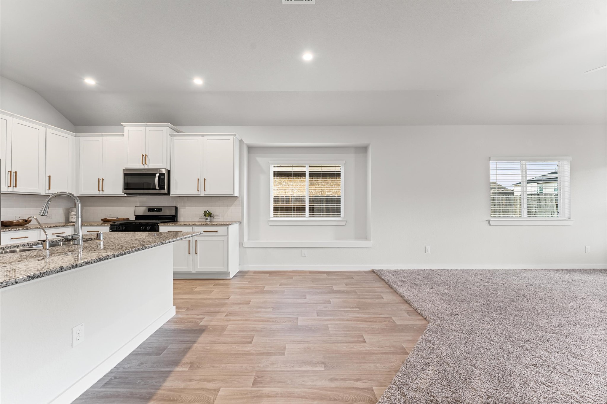 21431 Indigo Ruth Drive Spring, TX 77379 - Photo 5 of 19 a large white kitchen with granite countertop a stove a sink a window and white cabinets