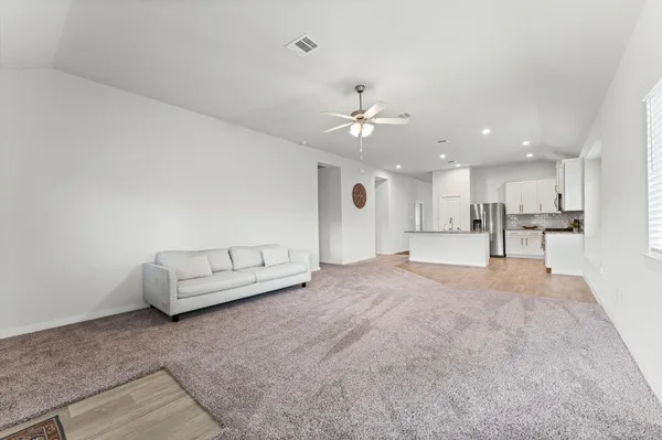 a living room with furniture and kitchen view