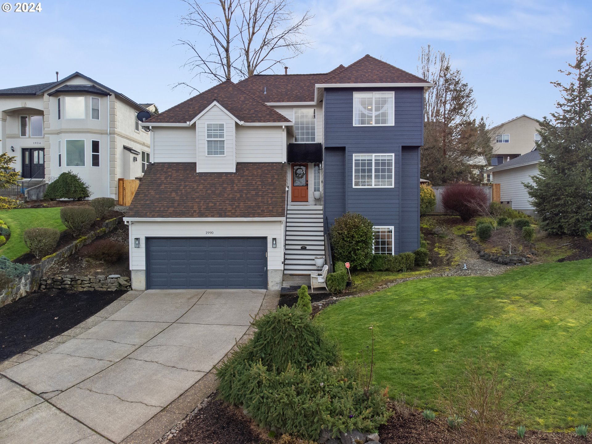 1990 Southwest Willow Parkway Gresham, OR 97080 - Photo 1 of 46 a front view of a house with a yard and garage