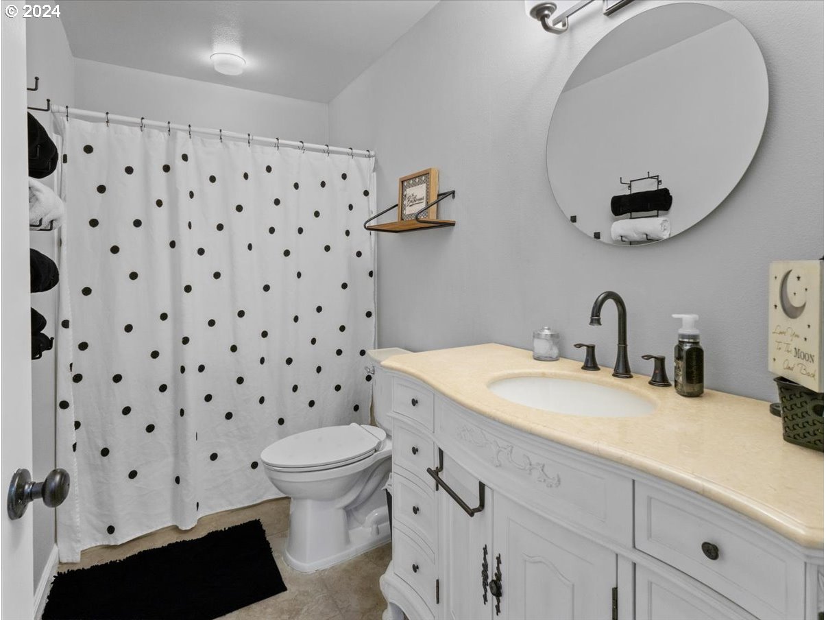 1990 Southwest Willow Parkway Gresham, OR 97080 - Photo 23 of 46 a bathroom with a sink a toilet and a mirror