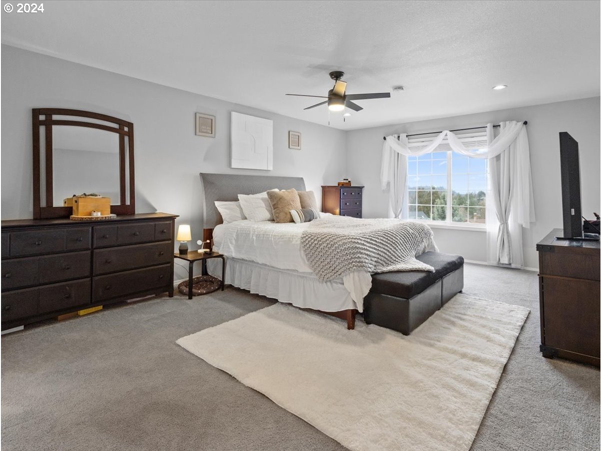 1990 Southwest Willow Parkway Gresham, OR 97080 - Photo 30 of 46 a bedroom with a large bed and a flat tv screen on dresser