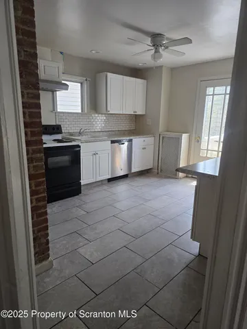 a kitchen with a sink a stove top oven and cabinetry