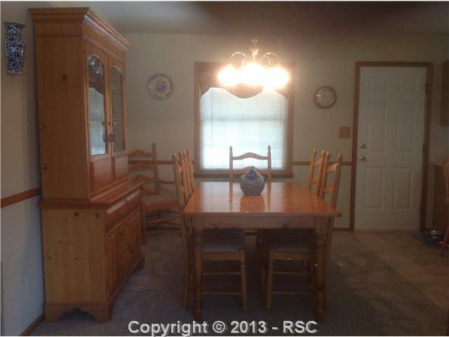 11190 Raygor Road Colorado Springs, CO 80908 - Photo 7 of 18 Separate dining area with walk out to back deck has room for a large table and hutch
