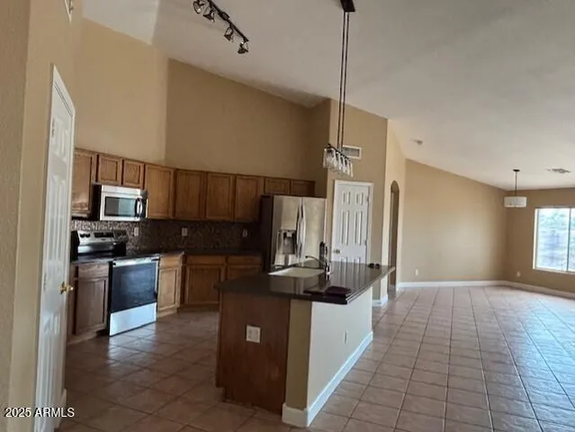 a kitchen with kitchen island granite countertop a sink appliances and cabinets