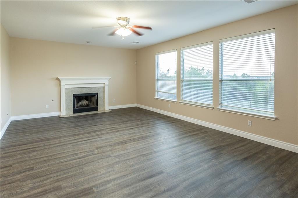 12017 Springs Head Loop Austin, TX 78717 - Photo 5 of 25 A comforting fireplace anchors this spacious living area, bathed in natural light from the three ample windows.
