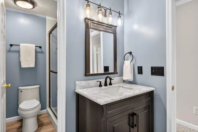 a bathroom with a granite countertop toilet sink and mirror