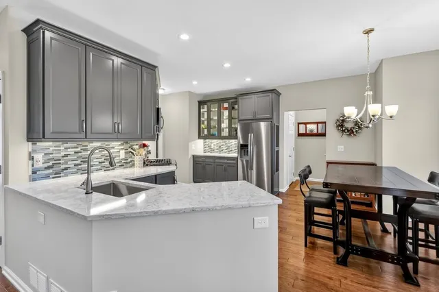 a kitchen with granite countertop a sink cabinets and refrigerator