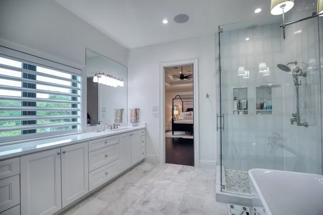 a bathroom with a double vanity sink a toilet a mirror and shower