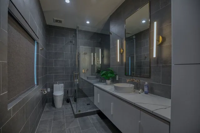 a bathroom with a double vanity sink toilet and a mirror