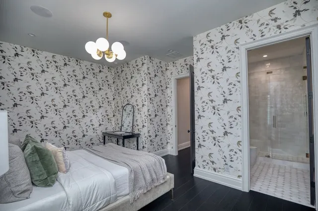 a spacious bedroom with a bed and a chandelier