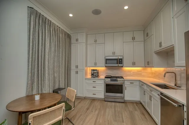a kitchen with stainless steel appliances granite countertop a stove a sink and a refrigerator